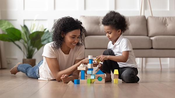 mum and child building home from toy bricks